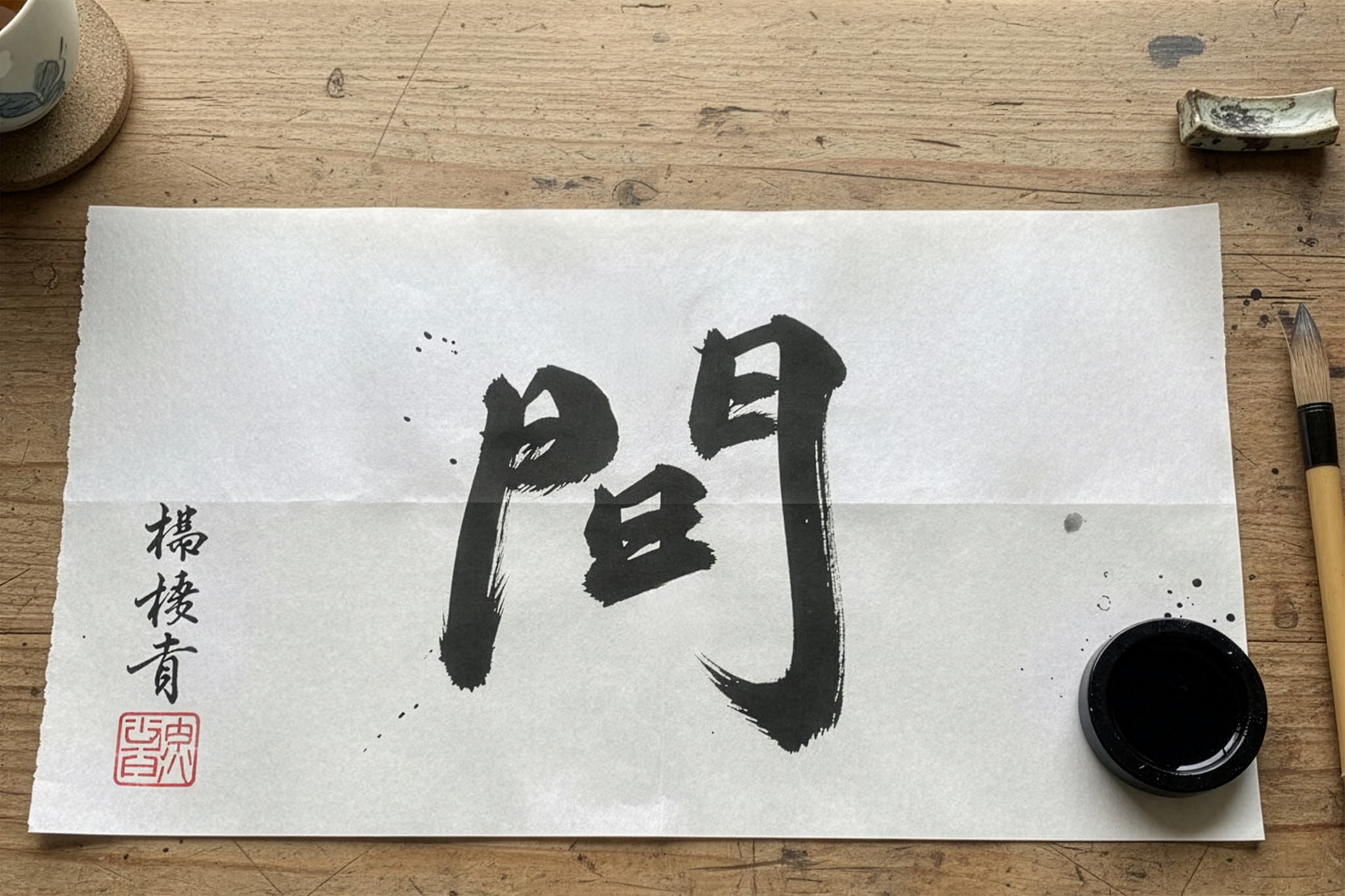 japoński znak kanji „間” oznaczający przestrzeń Ma, napisany pędzlem na papierze washi
