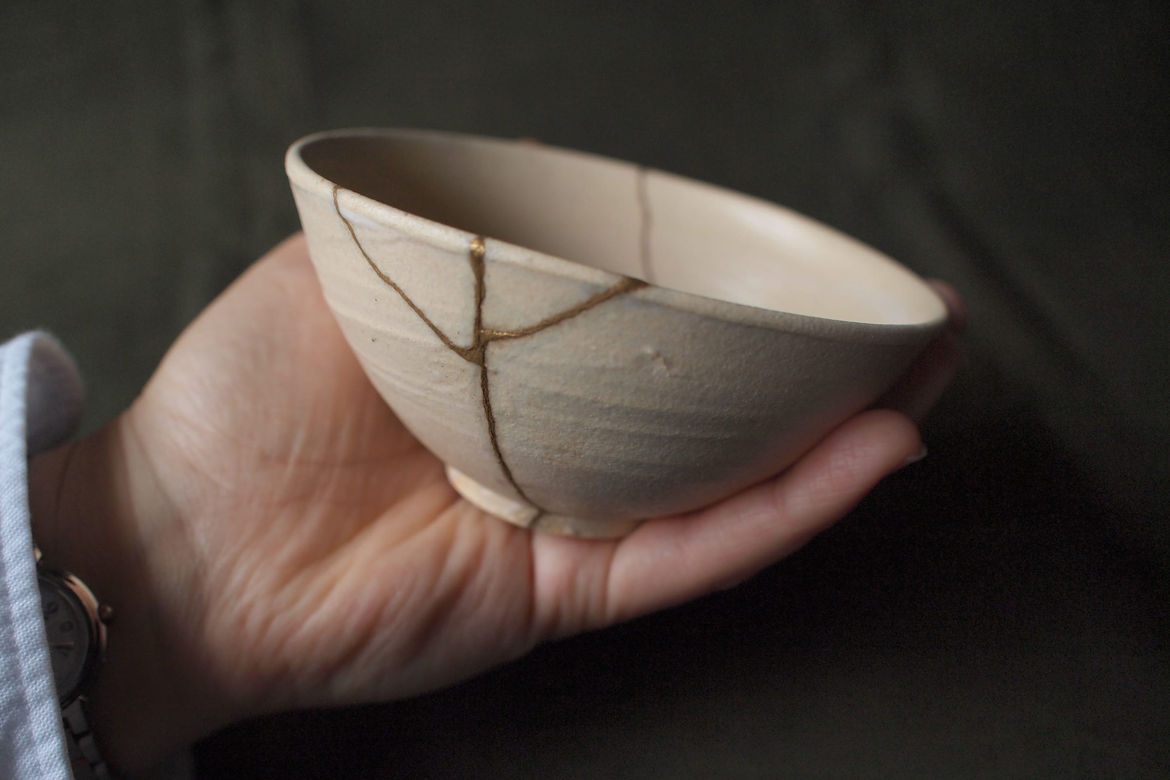 Zbliżenie złotego łączenia na ceramice naprawionej techniką Kintsugi